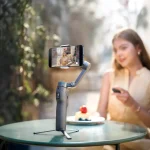 استفاده از گیمبال موبایل DJI Osmo Mobile 8P نسخه استاندارد روی میز کافه با کنترل کادر از راه ریموت FrameTap