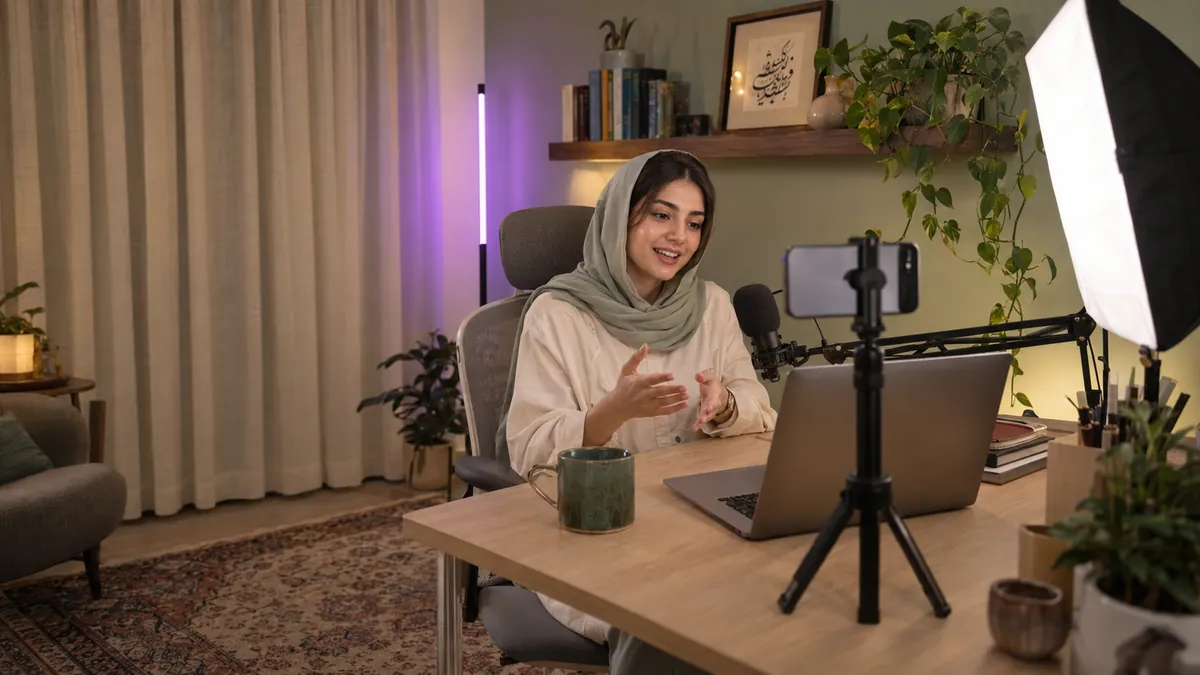 تجهیزات یوتیوب؛ راهنمای خرید وسایل یوتیوبری 6 گوشه یوتیوبری شیک در اتاق کار خانه ایرانی با سافتباکس، نور رنگی روی دیوار، میکروفون روی بازو و گوشی روی سهپایه